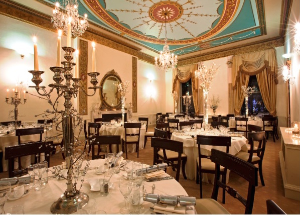 Heggie Room set for a festive christmas dinner with grand high ceilings with chandeliers and large candelabra centre pieces 28 Portland Place Christmas Party W1