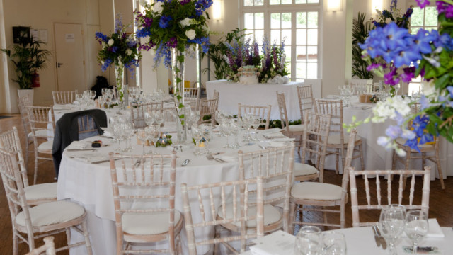 Mappin Pavilion with round tables with white linen and large beautiful floral centre pieces ZSL London Zoo Summer Party NW1