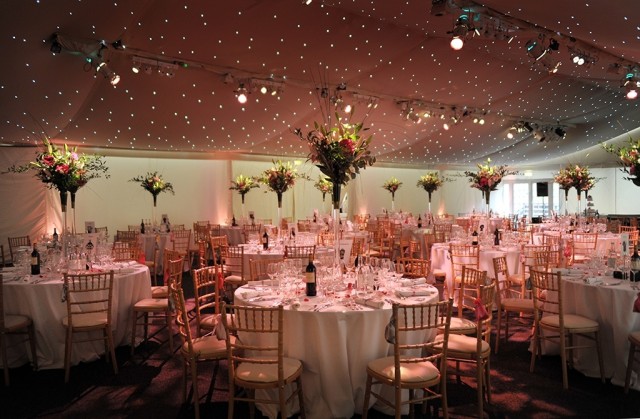 Conservatory at Painshill Venue Hire KT11, stunning centre pieces, ceiling lighting, largeround tables for dinner