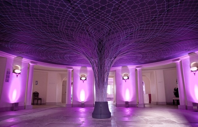 The Hub with large tree-like sculpture in the centre of the open room with purple lights shining up the walls Kensington Palace Venue Hire W8