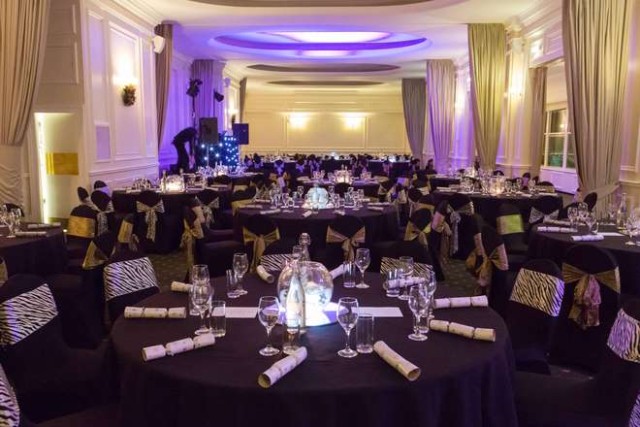 Prince Albert Suite set for a dinner with round tables, large floral centre pieces and white linen with chair covers ZSL London Zoo Venue Hire NW1