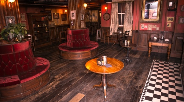 View of the event space with circular informal seating dark oak floor and private bar London Dungeon Venue Hire SE1